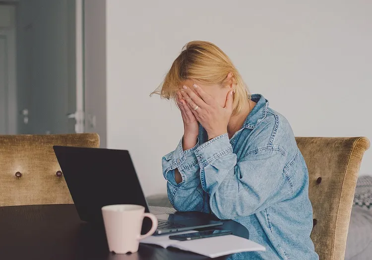 a woman sitting in front of her lap top working remotely