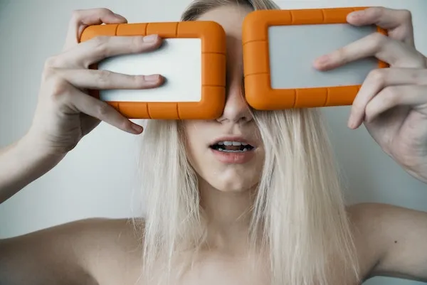 rugged harddrives held in front of a woman’s eyes