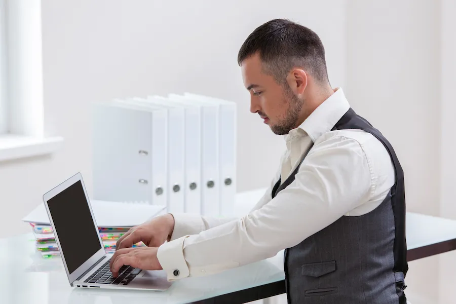 Young businessman using at laptop at desk